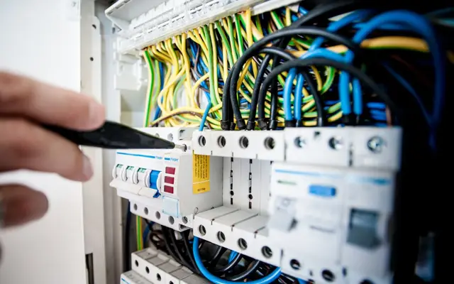 Eletricista testando disjuntores em um quadro de distribuição
