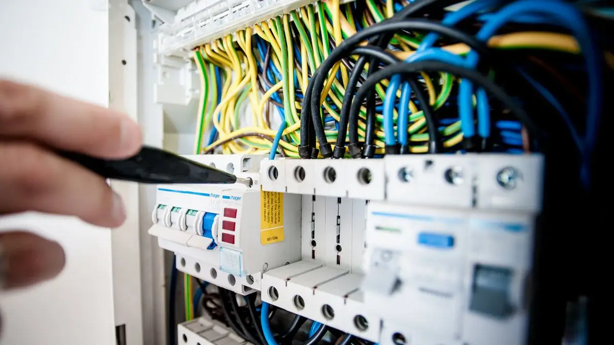 Eletricista testando disjuntores em um quadro de distribuição