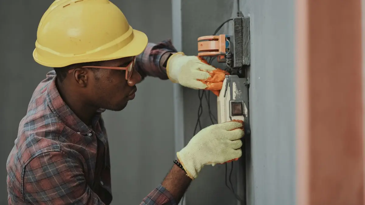 Eletricista com capacete fazendo manutenção em caixa elétrica externa
